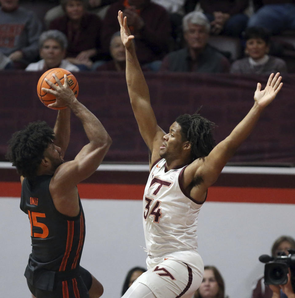 Miami's Norchad Omier (15) is defended by Virginia Tech's Mylyjael Poteat (34) during the first half of an NCAA college basketball game Saturday, Jan. 13, 2024, in Blacksburg, Va. (Matt Gentry/The Roanoke Times via AP)