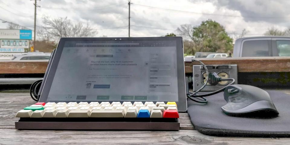 A Microsoft Surface on a table with a mechanical keyboard and a mouse