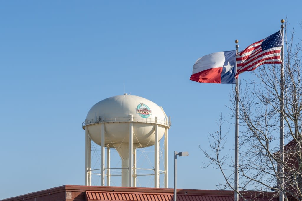 Pearland, Texas, USA - March 10, 2022: City of Pearland water tank with flags. The city of Pearland is a principal city within the Houston–The Woodlands–Sugar Land metropolitan statistical area.