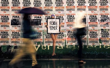 People walk past a sign reading "Out Temer" at the end of a protest against Brazil's President Michel Temer in Sao Paulo, Brazil, May 21, 2017. REUTERS/Nacho Doce