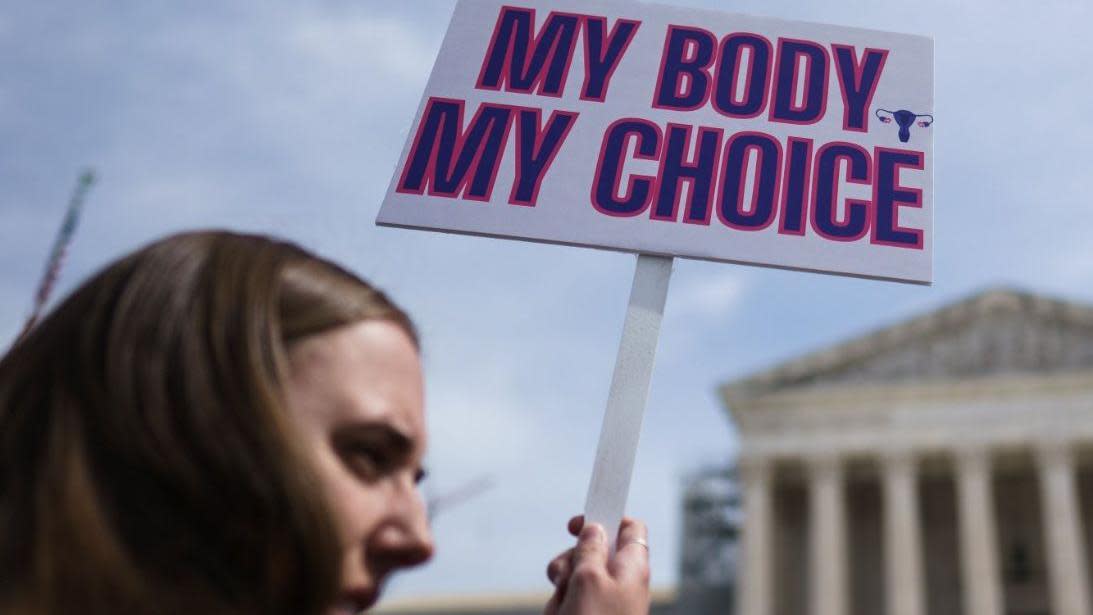 Woman holding placard that reads "my body my choice"