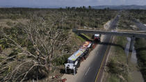 An overturned semi lays on the shoulder of a highway in the aftermath of Hurricane Otis, on the outskirts of Acapulco, Mexico, Friday, Oct. 27, 2023. (AP Photo/Felix Marquez)
