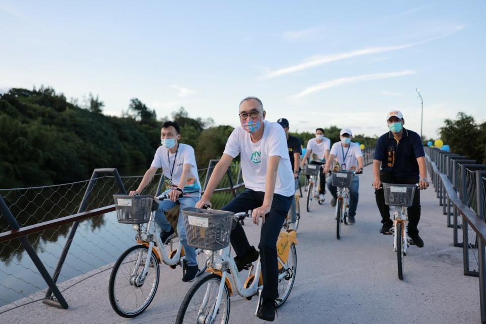 謝政達及金山萬里在地貴賓騎上景觀橋，體驗萬金自行車道。   圖：新北市城鄉局提供