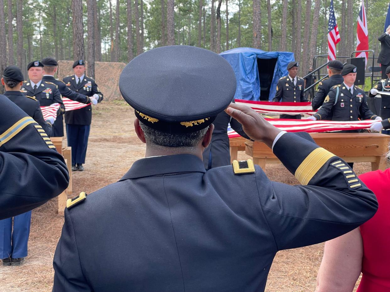 Members of the U.S. National Guard drape flags over the hand-made wooden coffins holding the remains of fourteen Revolutionary War soldiers recently excavated on the Camden Battlefield. In April, the South Carolina Battleground Preservation Trust held three days of ceremonies to honor the fallen soldiers.