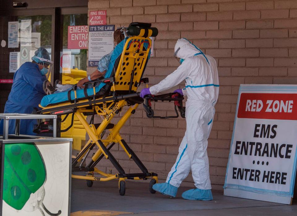 A patient is taken from an ambulance to the emergency room of a hospital in the Navajo Nation town of Tuba City, Arizona, during a 57-hour curfew period imposed to try to stop the spread of the COVID-19 virus in May 24, 2020.