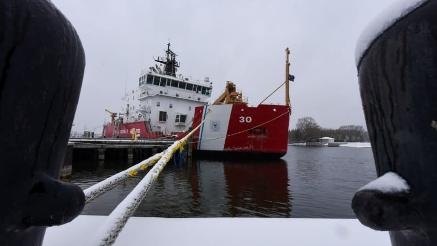 The U.S. Coast Guard Cutter Mackinaw sits at its dock in Cheboygan, tied off with several snow-covered ropes.