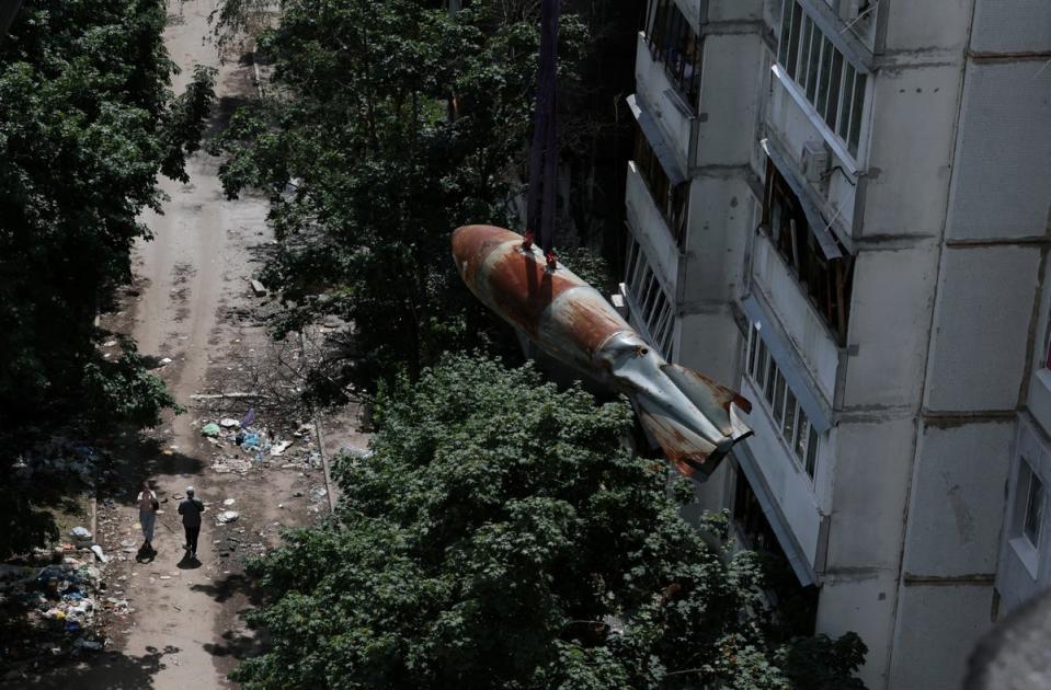 The bomb in mid-air as it is taken off the apartment block in Kharkiv (Reuters)