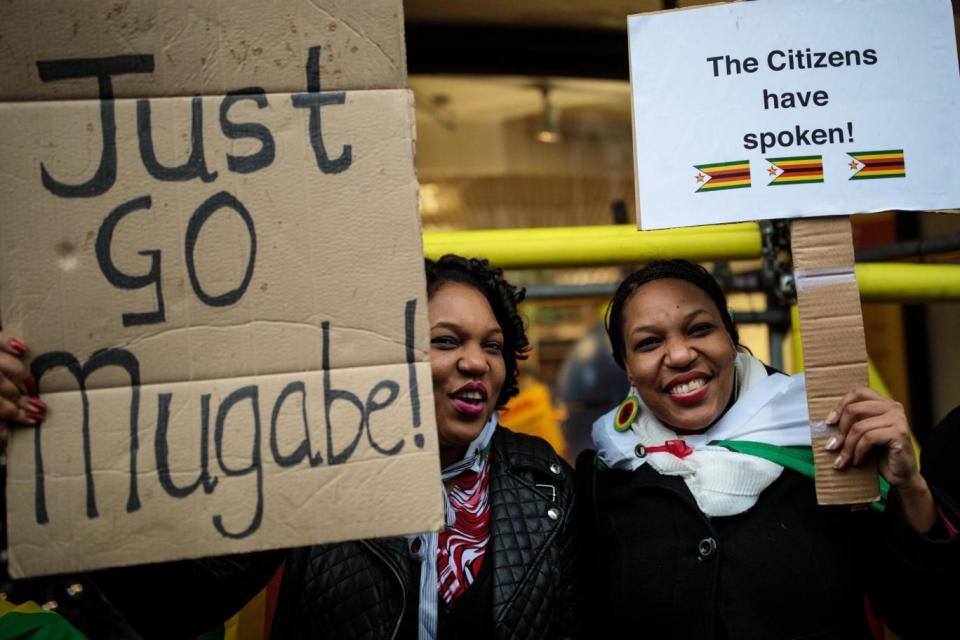 Protesters hold up signs at London's Zimbabwe Embassy (Getty Images)