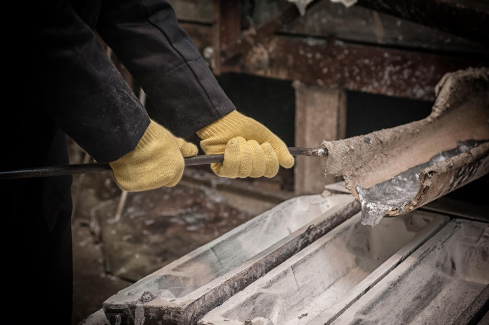 A person pouring molten aluminum.