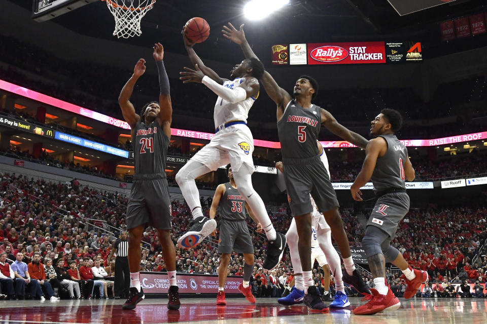 CORRECTS TO FIRST HALF NOT SECOND HALF - Pittsburgh guard Xavier Johnson (1) goes up for a layup between the defensive pressure of Louisville forwards Dwayne Sutton (24) and Malik Williams (5) during the fist half of an NCAA college basketball game in Louisville, Ky., Friday, Dec. 6, 2019. (AP Photo/Timothy D. Easley)