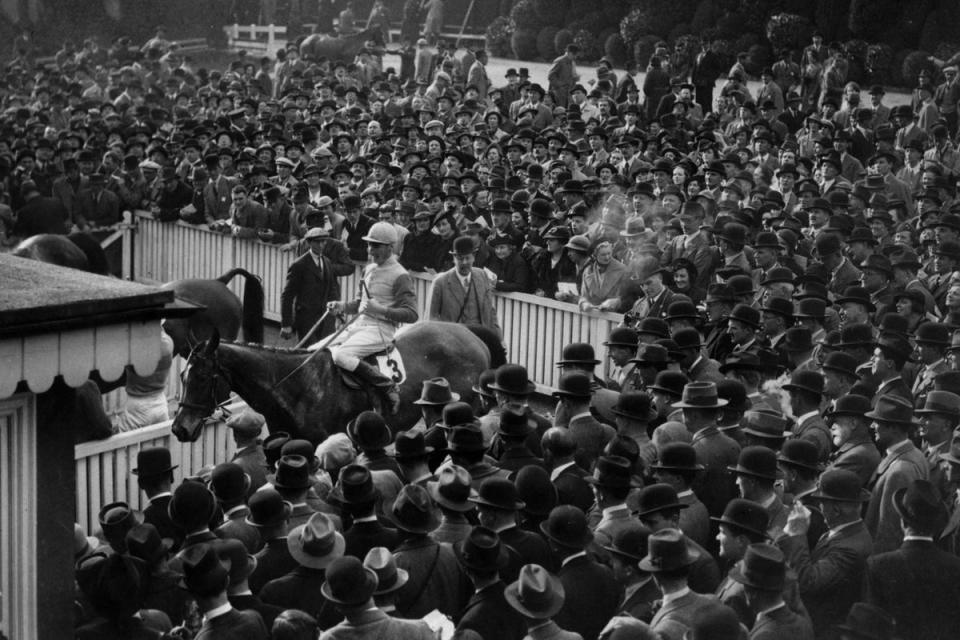 1938:  The crowd watching 'Morse Code', the winner of the Cheltenham Gold Cup enter the unsaddling enclosure (Fox Photos/Getty Images)