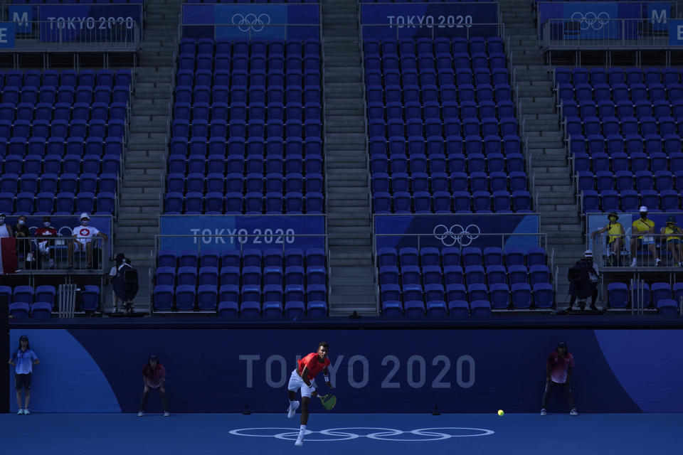 FILE - In this July 25, 2021, file photo, Felix Auger-Aliassime, of Canada, plays against Max Purcell, of Australia, during the first round of the tennis competition at the 2020 Summer Olympics in Tokyo, Japan. In arenas across Tokyo, athletes accustomed to feeding off the deafening roar of the crowd are searching for new ways to feel Olympic enthusiasm. (AP Photo/Seth Wenig, File)