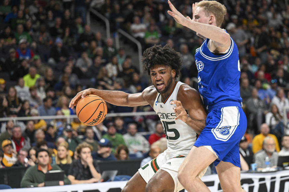 Miami forward Norchad Omier (15) is defended by Drake forward Nate Ferguson during the second half of a first-round college basketball game in the men's NCAA Tournament Friday, March 17, 2023, in Albany, N.Y. (AP Photo/Hans Pennink)