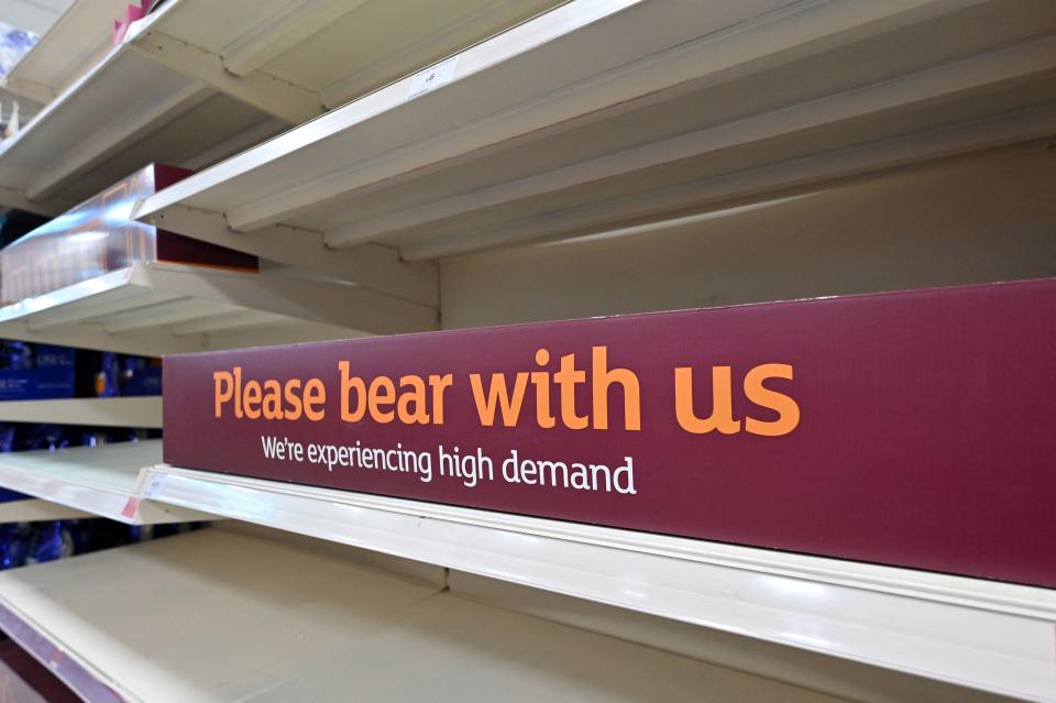 A sign requesting shoppers' patience about products temporarily out of stock is displayed on empty shelves in a supermarket at Nine Elms, south London on July 22, 2021. - British supermarkets and suppliers warned today of possible food shortages due to staff self-isolating, as rising coronavirus cases threaten chaos after the government controversially eased all restrictions earlier this week. (Photo by JUSTIN TALLIS / AFP) (Photo by JUSTIN TALLIS/AFP via Getty Images)