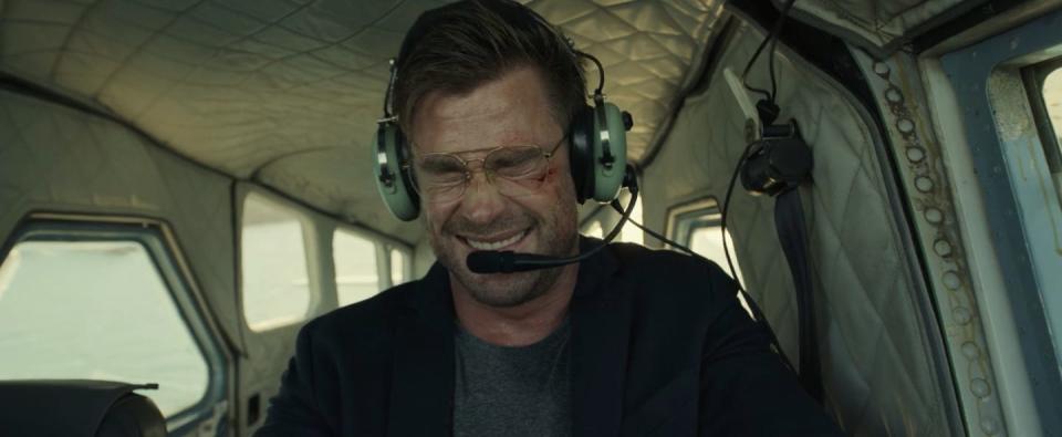 Chris Hemsworth laughing while flying a plane