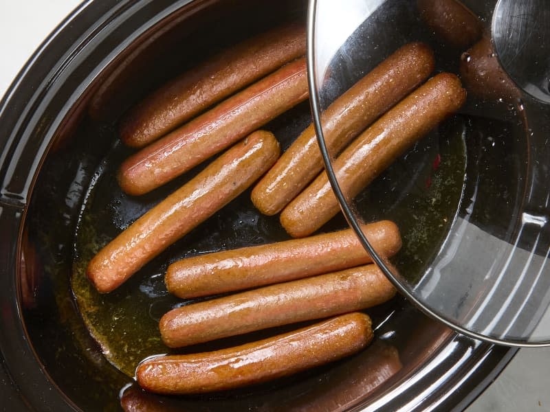 overhead photo of hot dogs cooking in a slow cooker
