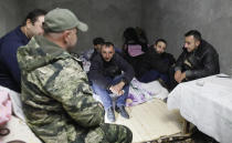 Men sit in a bomb shelter during shelling by Azerbaijan's artillery during a military conflict in Stepanakert, the separatist region of Nagorno-Karabakh, Friday, Oct. 23, 2020. Heavy fighting raged Friday over Nagorno-Karabakh even as top diplomats from Armenia and Azerbaijan visited Washington for negotiations on settling the neighboring countries' decades-long conflict. (AP Photo)