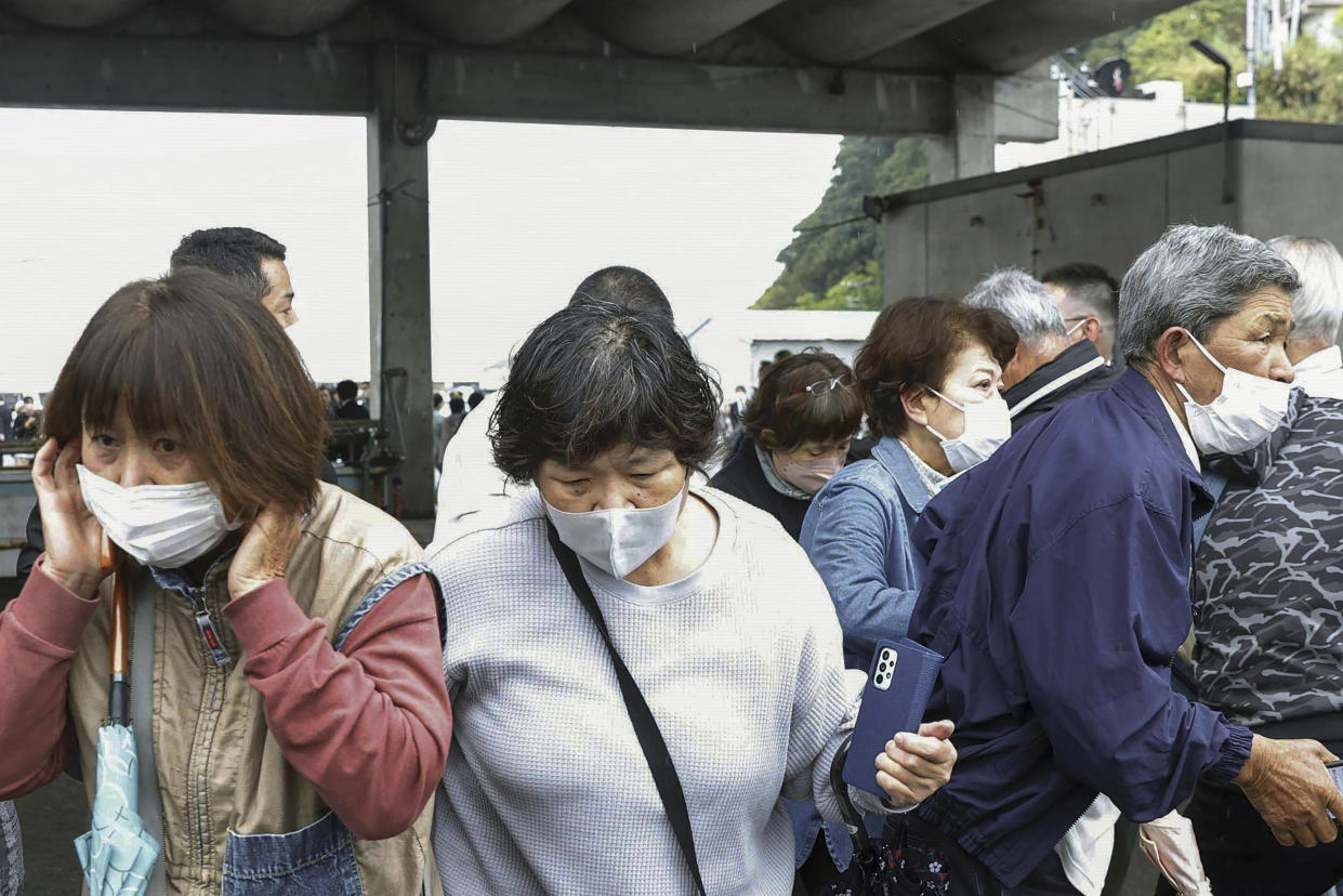 Residents try to flee after what appeared to be a smoke bomb was thrown at a port in Wakayama, western Japan Saturday, April 15, 2023. Japan’s NHK television reported Saturday that a loud explosion occurred at the western Japanese port during Prime Minister Fumio Kishida’s visit, but there were no injuries. (Kyodo News via AP)