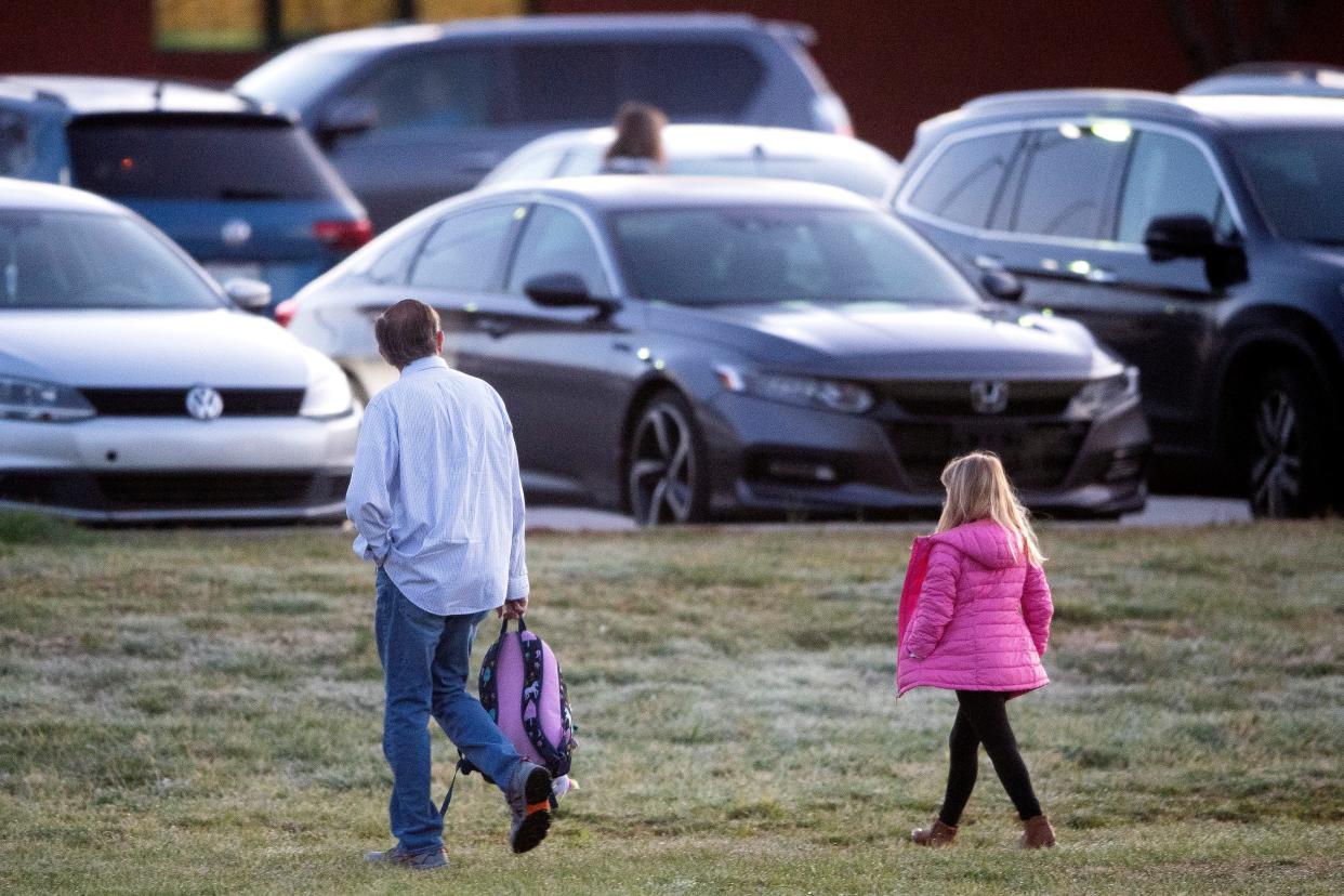 A parent walks their child to the entrance of Hardin Valley Elementary School on Monday after federal judge J. Ronnie Greer suspended his mask rule for Knox County Schools last week.