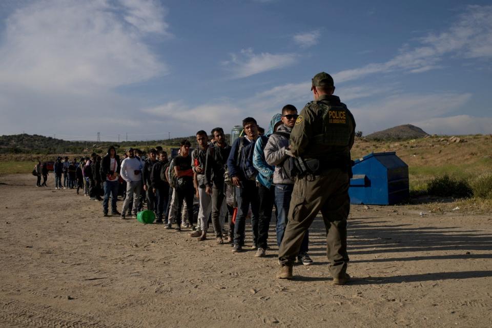 Immigrants surrender to a border agent  at the US-Mexico border in California on May 15. (REUTERS)