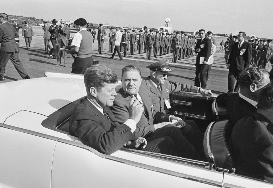 President John F. Kennedy starts out on a quickie auto tour of the missile base at Cape Canaveral, Fla., Nov. 16, 1963. Accompanying him is James E. Webb, administrator of the National Aeronautics and Space Administration, center, and Maj. Gen. Leighton I. Davis, commander of the Air Force Missile Test Center, right. (AP Photo)