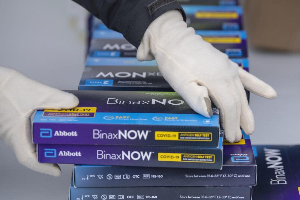 oungstown City Health Department worker Faith Terreri grabs two at-home COVID-19 test kits to be handed out during a distribution event, Dec. 30, 2021, in Youngstown, Ohio. (AP Photo/David Dermer, File)