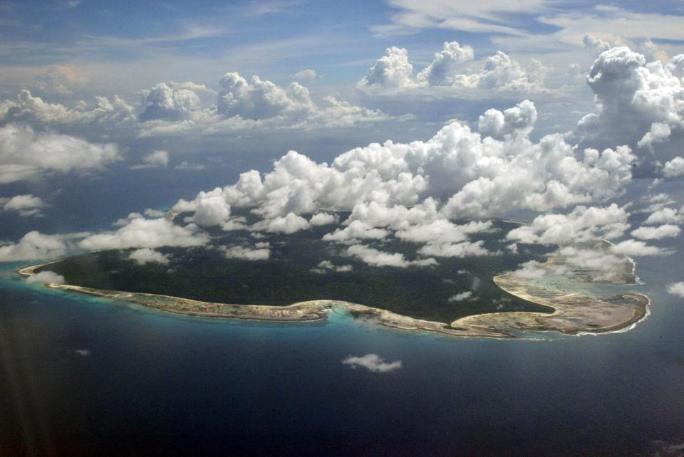 FILE – In this Nov. 14, 2005 file photo, clouds hang over the North Sentinel Island, in India's southeastern Andaman and Nicobar Islands. An American is believed to have been killed by an isolated Indian island tribe known to fire at outsiders with bows and arrows, Indian police said Wednesday, Nov. 21, 2018. Police officer Vijay Singh said seven fishermen have been arrested for facilitating the American's visit to North Sentinel Island, where the killing apparently occurred. Visits to the island are heavily restricted by the government. (AP Photo/Gautam Singh, File)