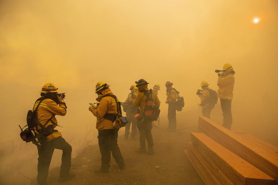 Firefighters with Cal Fire are enveloped in smoke as fire from the Green Fire passes by near homes on Hidden Glen Lane and Hidden Hills Road in Yorba Linda, Calif., Monday, Oct. 26, 2020. (Leonard Ortiz/The Orange County Register via AP)