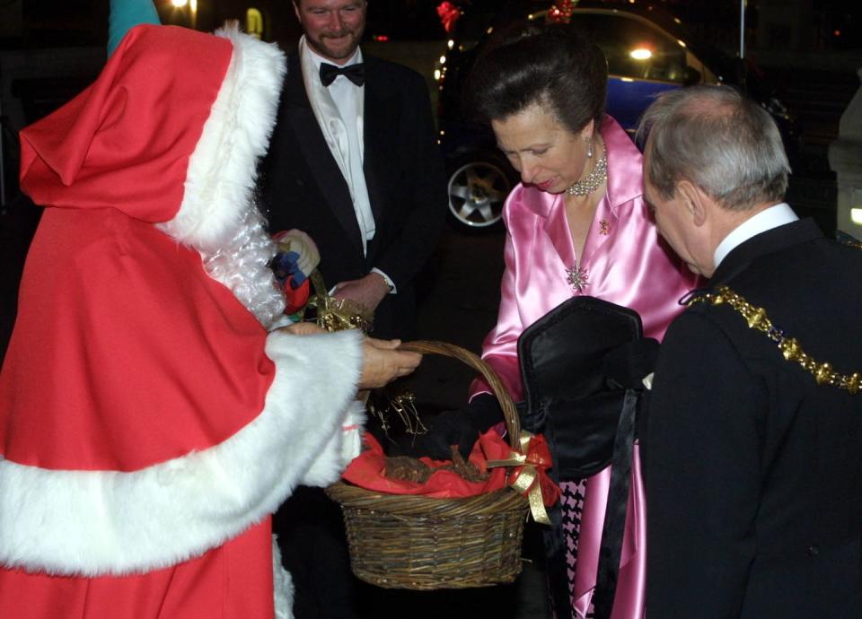 <p>Princess Anne takes a biscuit from Santa's basket during the Save The Children Festival of Trees at the Natural History Museum.</p>