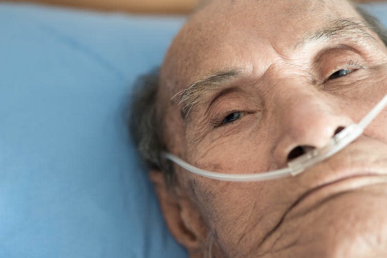 An elderly man receiving supplemental oxygen.