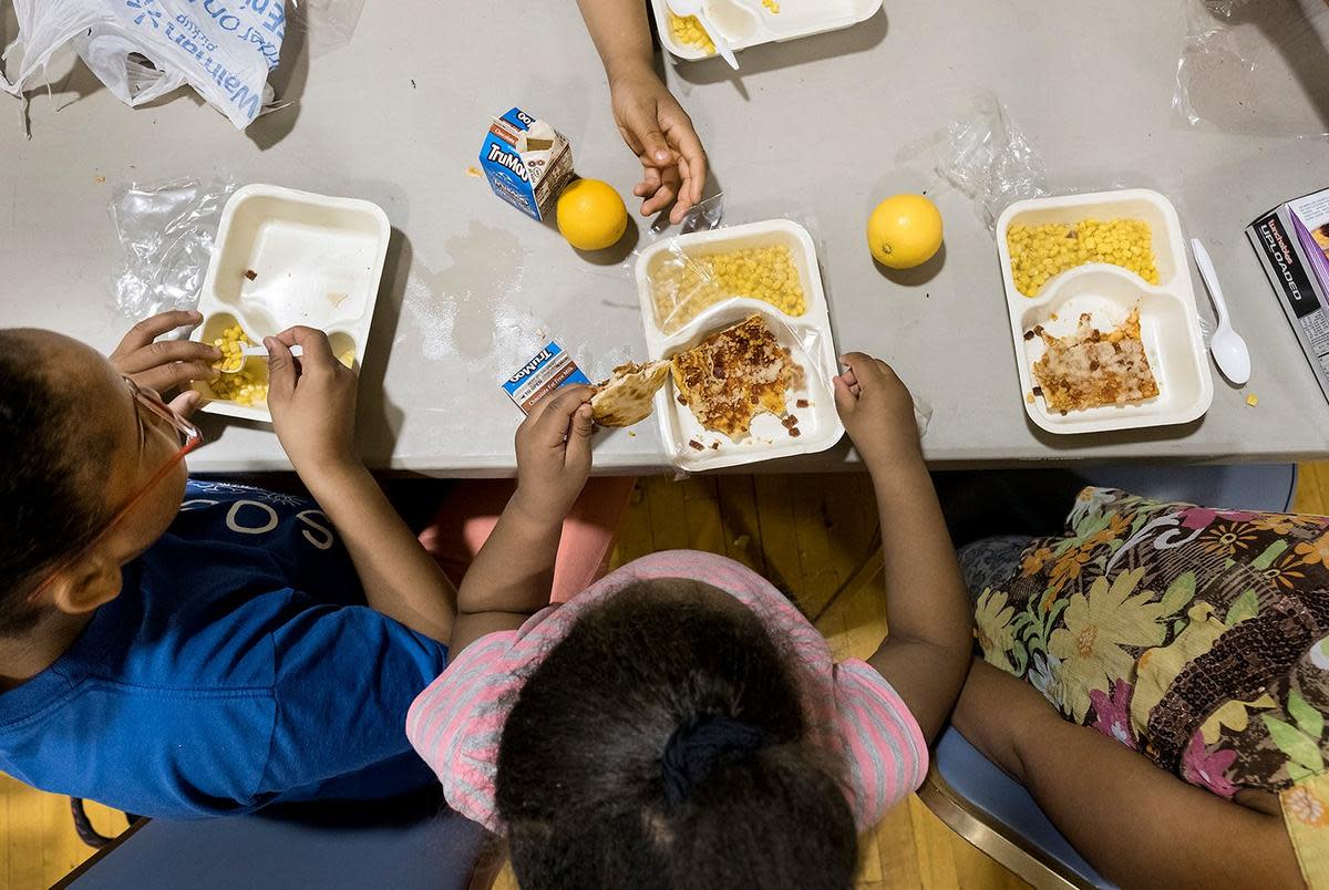 Siblings Stacy Hurd, 11, Angelica Hurd, 5, and Sheniya Hurd, 8, eat a free meal together at Jarvis Christian College in Hawkins, one of more than 70 sites the East Texas Food Bank sponsors in the summer.