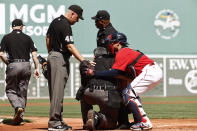 Home plate umpire Manny Gonzalez, second from front right, is helped to one knee by Boston Red Sox catcher Christian Vazquez, right, after collapsing during the first inning of a baseball game against the Tampa Bay Rays, Monday, Sept. 6, 2021, at Fenway Park in Boston. Gonzalez Left the game. (AP Photo/Winslow Townson)