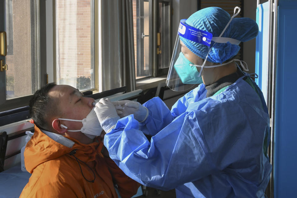 In this photo released by Xinhua News Agency, a medical worker administers a second booster dose of COVID-19 vaccine for a resident through the nose, at a temporary vaccination site in Beijing, Saturday, Dec. 17, 2022. Chinese health authorities on Monday, Dec. 19, 2022 announced two additional COVID-19 deaths, both in the capital Beijing, that were the first reported in weeks and come during an expected surge of illnesses after the nation eased its strict "zero-COVID" approach. (Ren Chao/Xinhua via AP)