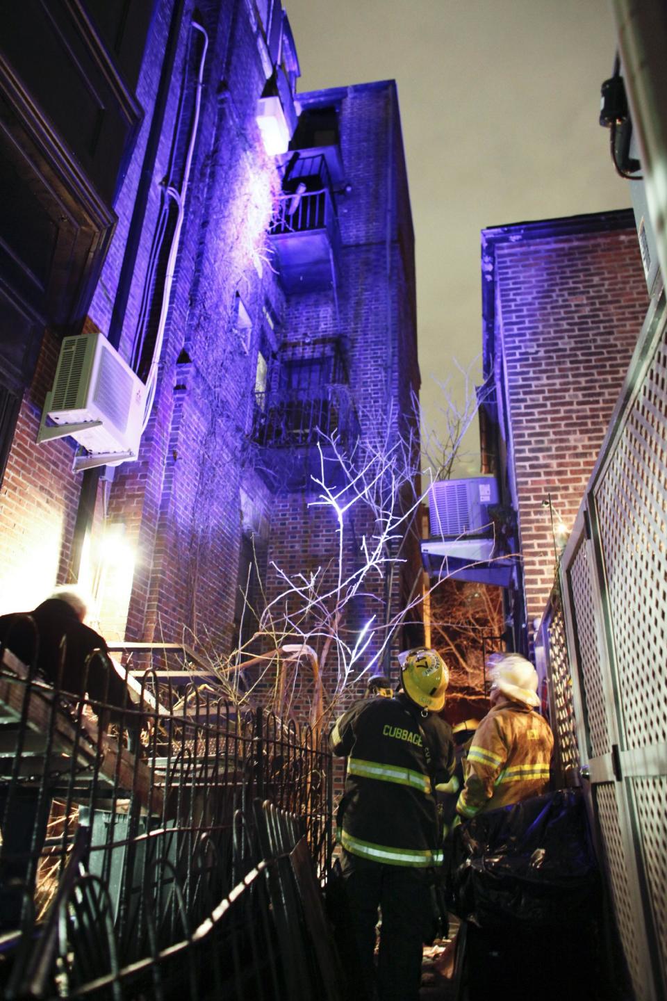 Firefighters look up at a fourth-floor balcony Sunday, Jan. 12, 2014 that collapsed at the historic John C. Bell building around midnight Saturday in the Rittenhouse Square section of Philadelphia, killing a young man and injuring two women, police said. Police say a 22-year-old man who suffered severe head and neck injuries in the fall was pronounced dead at a hospital early Sunday morning. The two women are in their 20s and suffered broken bones in their backs. They are listed in stable condition at two city hospitals. The man and two women, who were attending a birthday party, had stepped out onto the balcony to smoke cigarettes when the collapse occurred, authorities said. (AP Photo/ Joseph Kaczmarek)