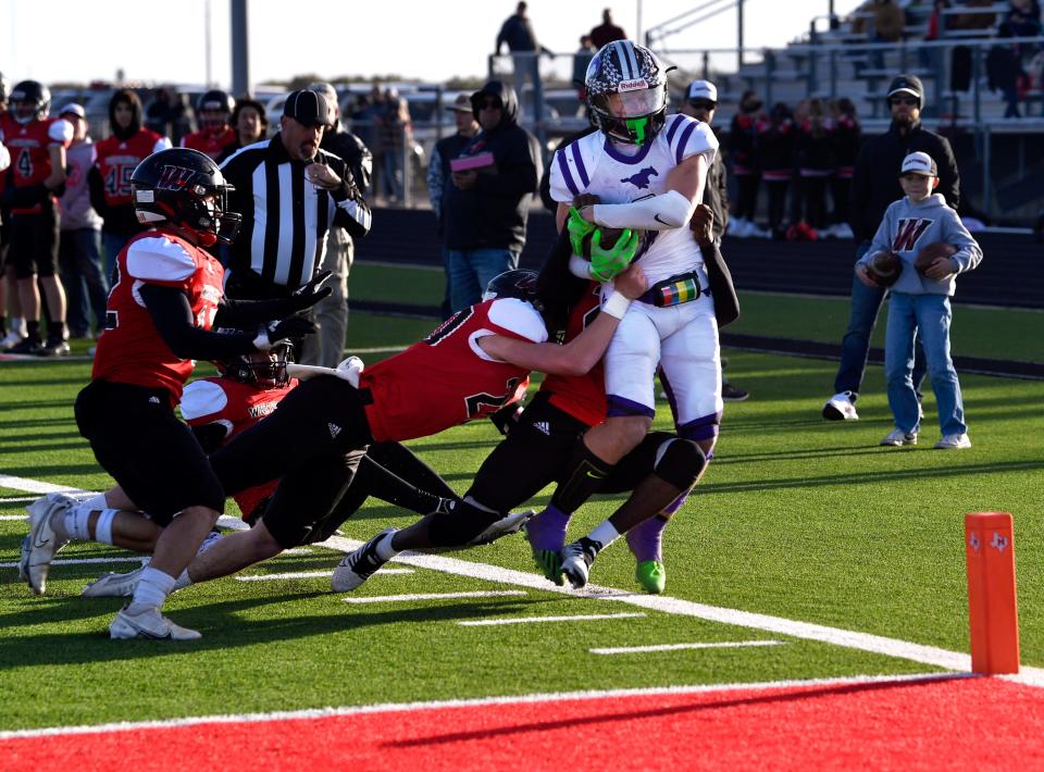 Benjamin running back Grayson Rigdon is knocked out of bounds by more than half of the Whitharral defense during Saturday's Class 1A Division II six-man semifinal playoff in Hermleigh.