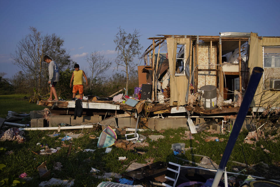 FILE - In this Sept. 4, 2021, file photo, Aiden Locobon, left, and Rogelio Paredes look through the remnants of their family's home destroyed by Hurricane Ida, in Dulac, La. (AP Photo/John Locher, File)