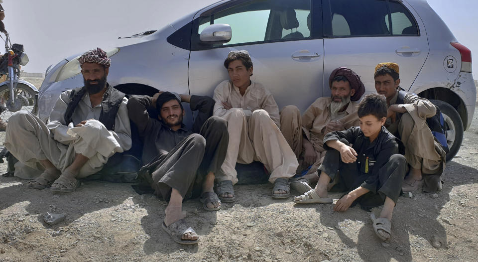 Stranded people gather and wait to open the border which was closed by authorities, in Chaman, Pakistan, Saturday, Aug. 7, 2021. Chaman border crossing is one of busiest border crossings between Pakistan and Afghanistan. Thousands of Afghans and Pakistanis cross daily and a steady stream of trucks passes through, taking goods to land-locked Afghanistan from the Arabian Sea port city of Karachi in Pakistan. (AP Photo/Tariq Achakzai)