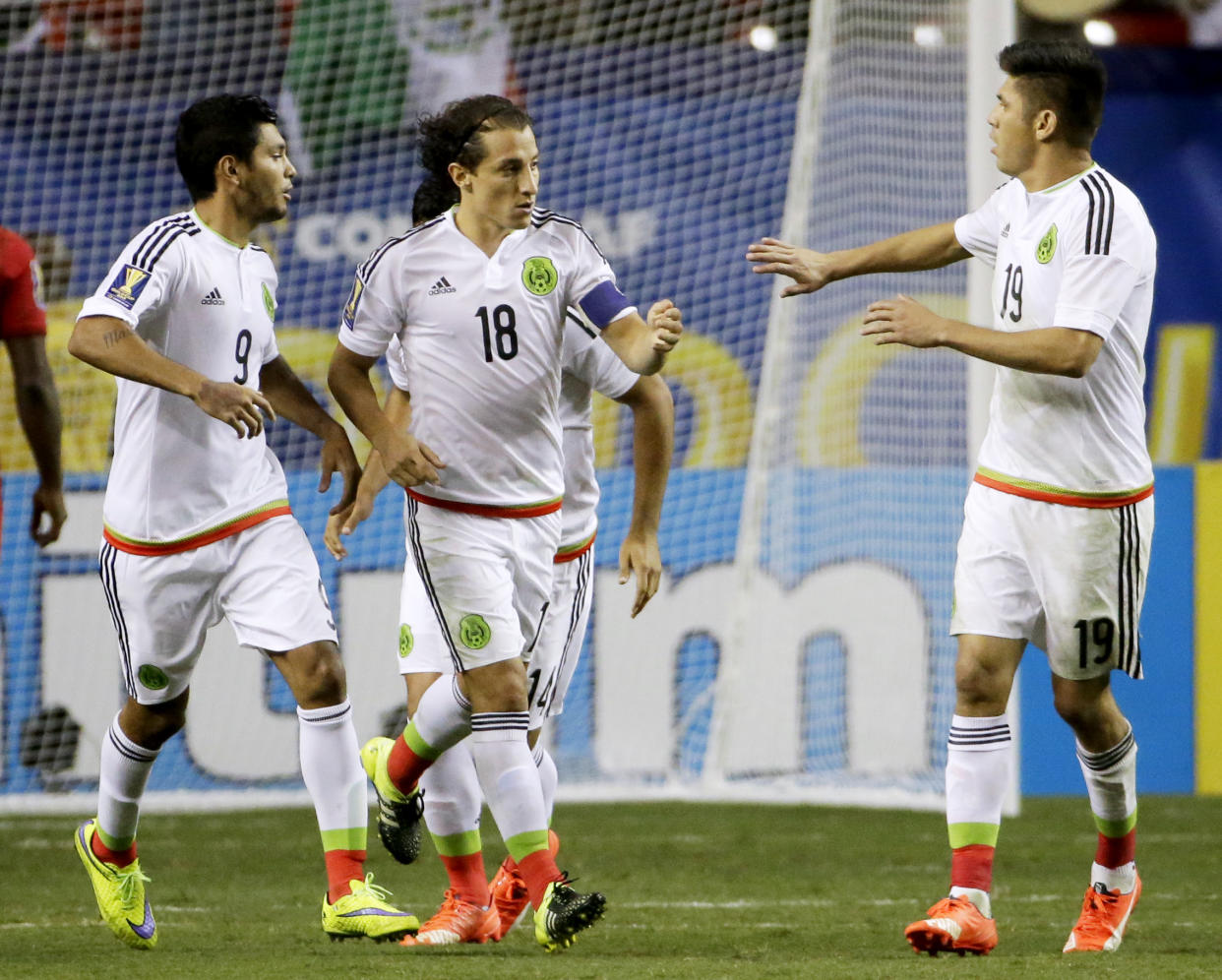 Mexico’s Andres Guardado, center, is congratulated by teammates Jesus Corona, left, and Oribe Peralta after scoring on a penalty kick during the second half of a CONCACAF Gold Cup soccer semifinal against Panama on Wednesday, July 22, 2015, in Atlanta. (AP Photo/David Goldman)