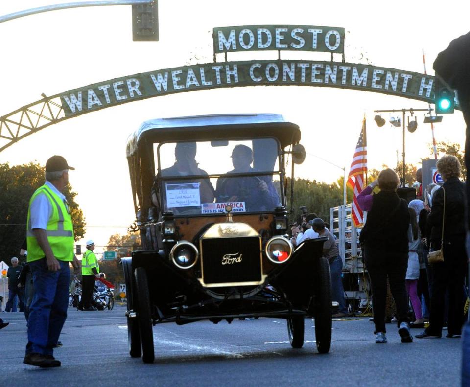 Autos que abarcan 100 años desfilan bajo el arco, incluido este Modelo T-Ford de 1913, en la celebración del centenario del Arco de Modesto, el 26 de octubre de 2012.