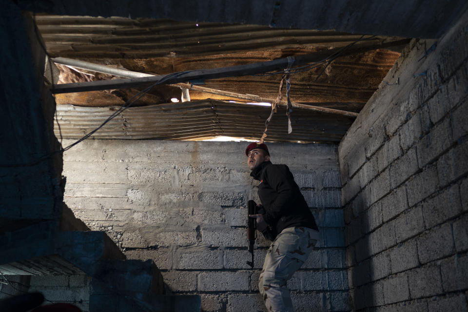 In this April 5, 2019 photo, an Iraqi army 20th division soldier searches a house during a raid in Badoush, Iraq. A year and a half after the Islamic State group was declared defeated in Iraq, efforts to find remnants rely on intelligence operations, raids and searches for sleeper cells among the population. (AP Photo/Felipe Dana)