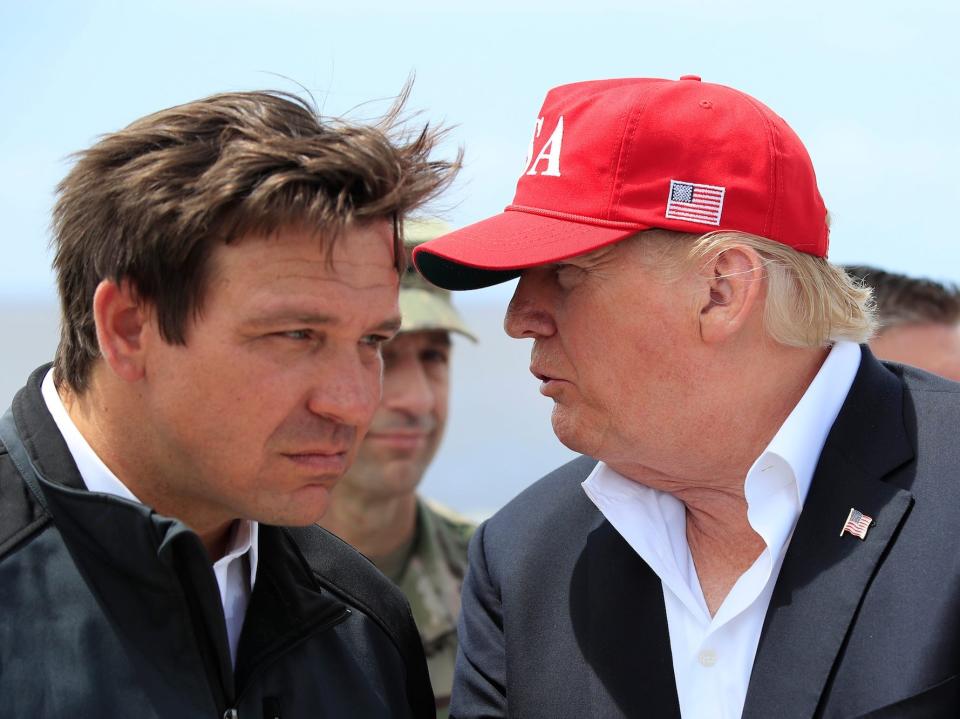 President Donald Trump talks to Florida Gov. Ron DeSantis, left, during a visit to Lake Okeechobee and Herbert Hoover Dike at Canal Point, Fla., March 29, 2019.