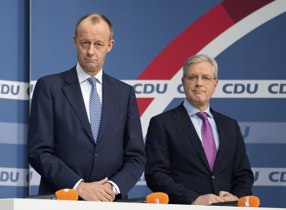 New elected party chairman Friedrich Merz, left, and candidate Norbert Roettgen, right, attend a press conference of the German Christian Democratic Party (CDU) at the party's headquarters in Berlin, Germany, Friday, Dec. 17, 2021 to announce the results of a ballot on who will become its new leader. (AP Photo/Michael Sohn)