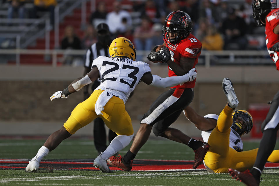 West Virginia's Tykee Smith (23) tackles Texas Tech's Myles Price (18) during the first half of an NCAA football game on Saturday, Oct. 24, 2020, in Lubbock, Texas. (AP Photo/Brad Tollefson)