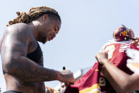 CORRECTS TO COMMANDERS DEFENSIVE END CHASE YOUNG, NOT WIDE RECEIVER TERRY MCLAURIN AS ORIGINALLY SENT - Washington Commanders defensive end Chase Young signs autographs for fans at the end of an NFL football practice at the team's training facility, Friday, July 28, 2023, in Ashburn, Va. (AP Photo/Stephanie Scarbrough)