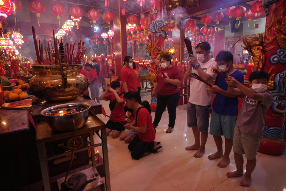 Worshippers wearing face masks offer prayer at Hok Lay Kiong temple in Bekasi, Indonesia, Sunday, Jan 22, 2023. The Lunar New Year which marks the Year of the Rabbit in the Chinese zodiac. (AP Photo/Achmad Ibrahim)