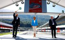 CEO of SBB Ducrot and CEO AlpTransit Gotthard Schwank wave signalling discs during the opening ceremony of the newly built Ceneri Base Tunnel near Camorino