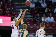 Wisconsin's D'Mitrik Trice (0) shoots a 3-point basket over Michigan State's Kyle Ahrens during the first half of an NCAA college basketball game Saturday, Feb. 1, 2020, in Madison, Wis. (AP Photo/Andy Manis)