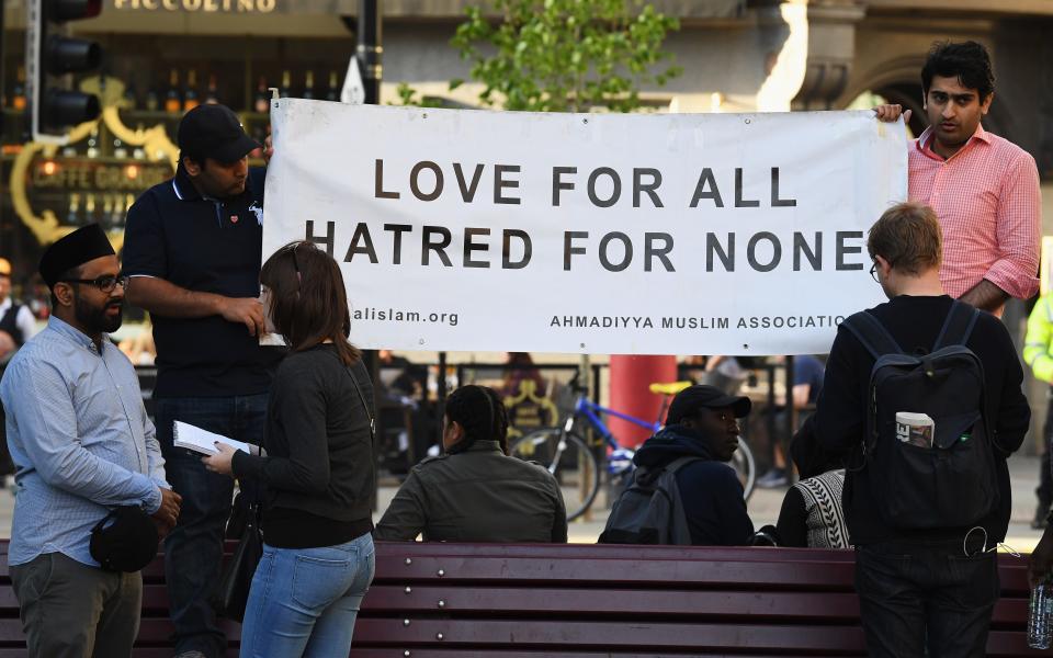 Members of the Ahmadiyya Muslim Association gather after the attack - Credit: Jeff J Mitchell/Getty Images