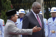 Indonesian Defense Minister Prabowo Subianto, left, guides U.S. Secretary of Defense Lloyd Austin during a welcoming ceremony in Jakarta, Indonesia, Monday, Nov. 21, 2022. (AP Photo/Tatan Syuflana)