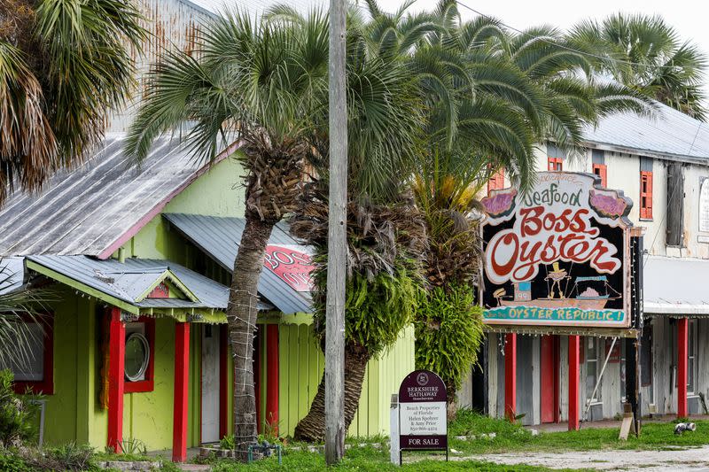 A "for sale" sign is seen outside the Boss Oyster restaurant, which has been closed since Hurricane Michael hit the area in October 2018, in Apalachicola, Florida